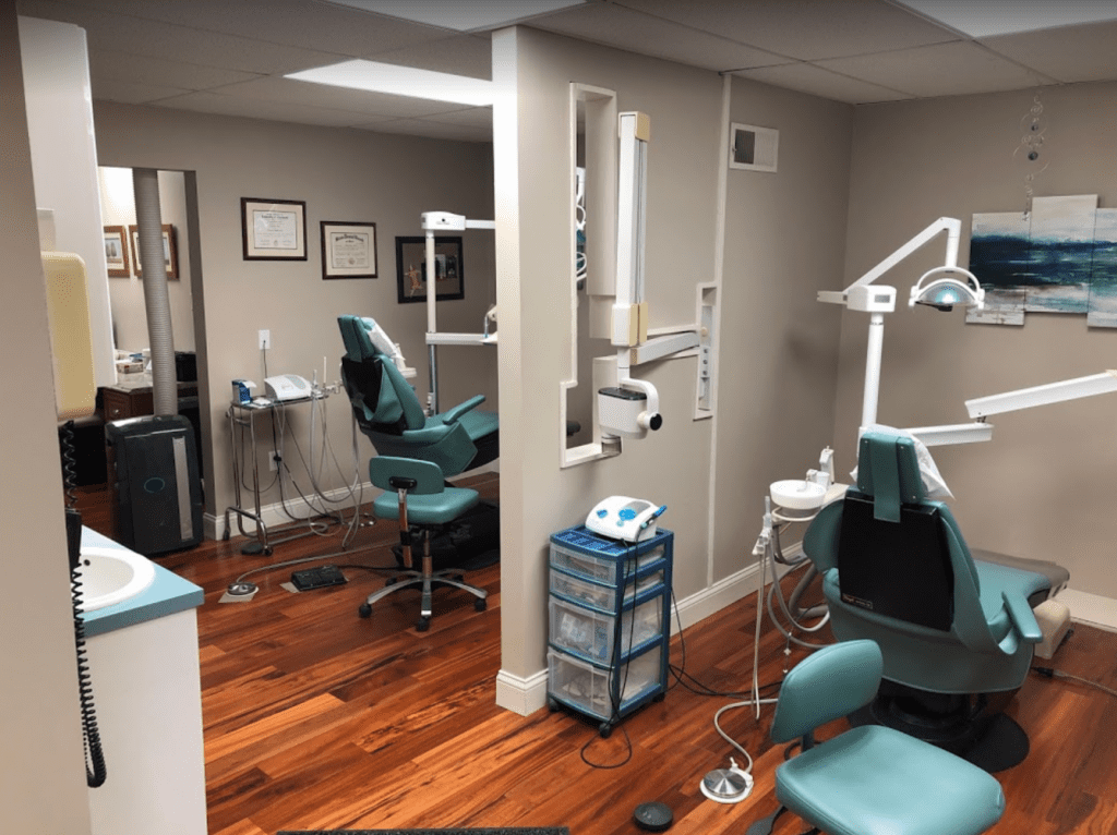 A dentist 's office with chairs and equipment on the floor.