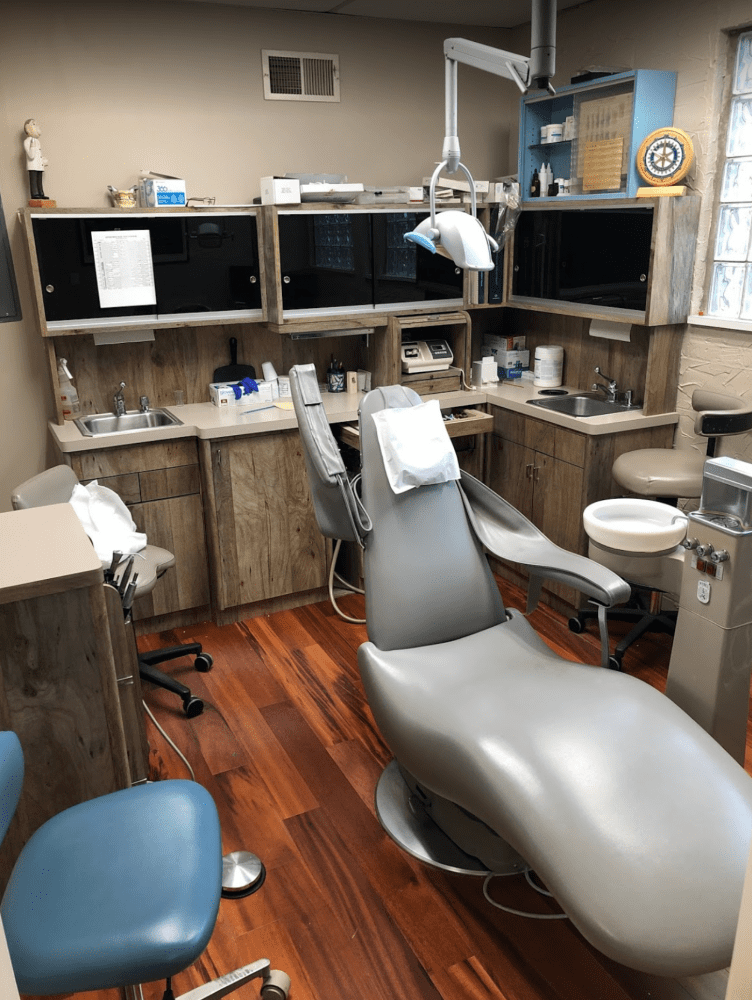 A dentist 's office with chairs and dental equipment.