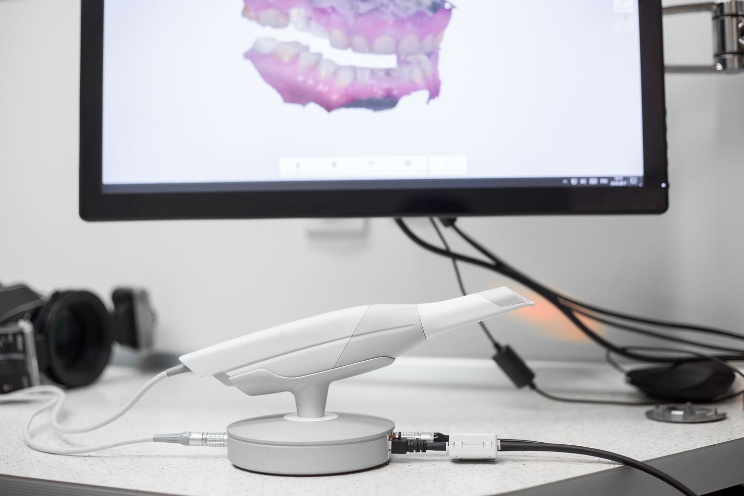 A computer monitor and a white toothbrush on top of a desk.