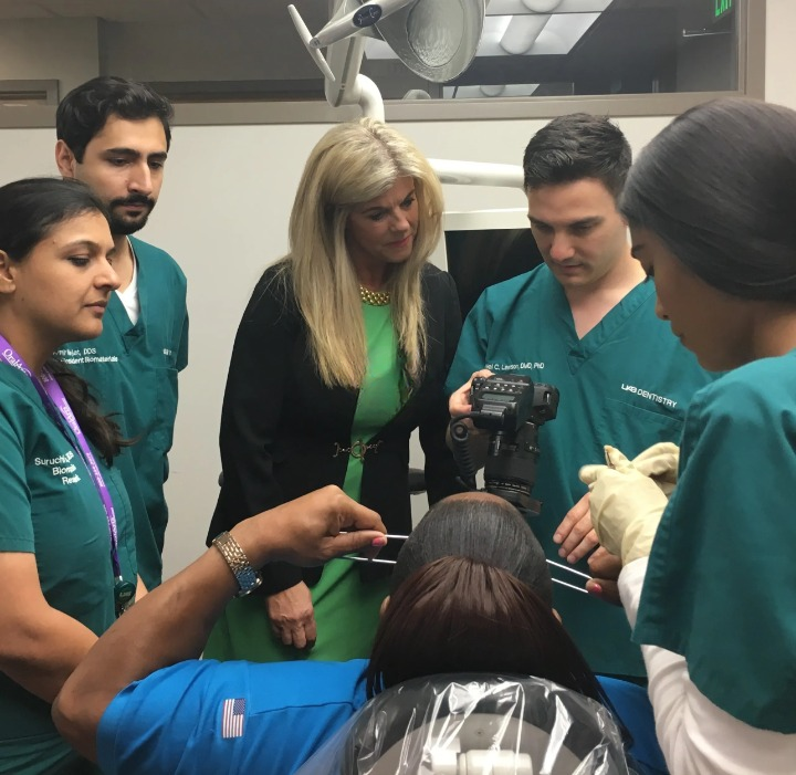 A group of people in green shirts and blue scrubs.