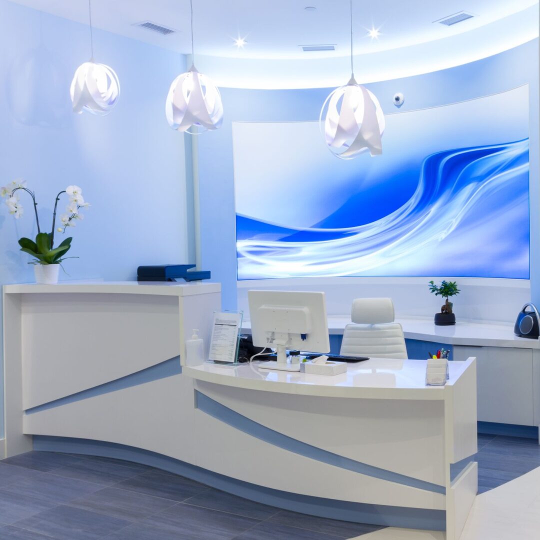 A reception desk with a large blue wave on the wall.