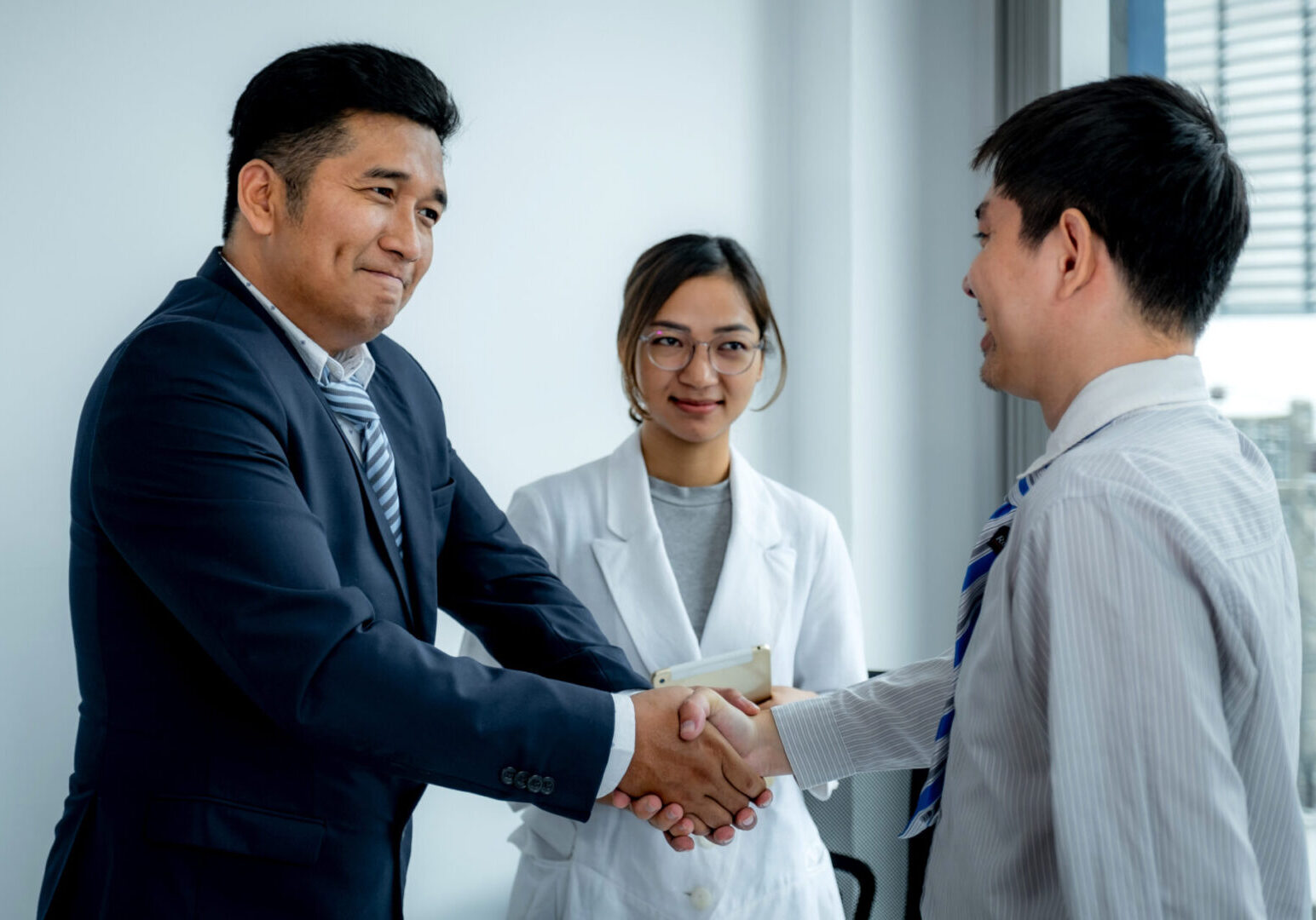 A group of people shaking hands in an office.