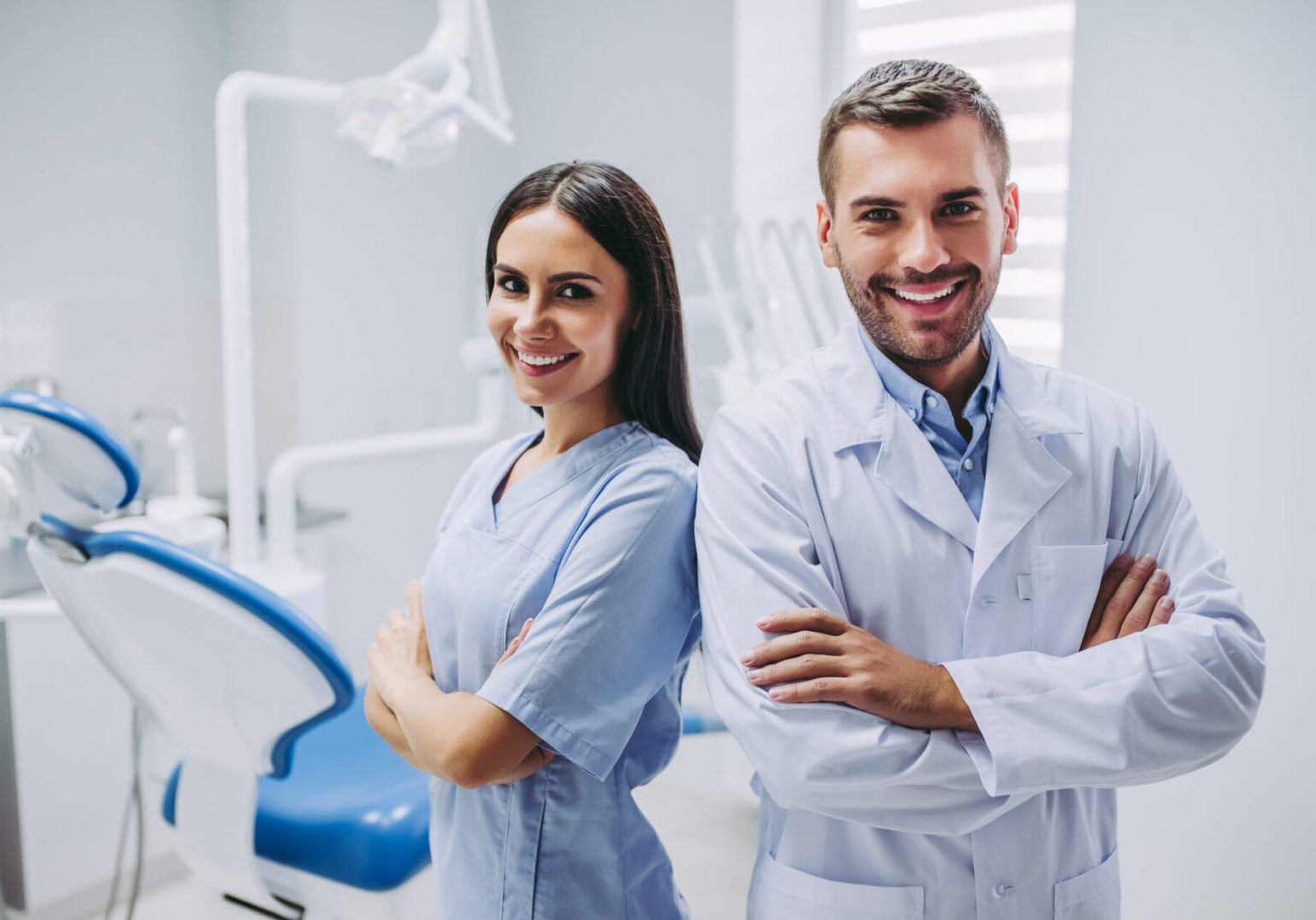 Two dentists standing next to each other in a room.